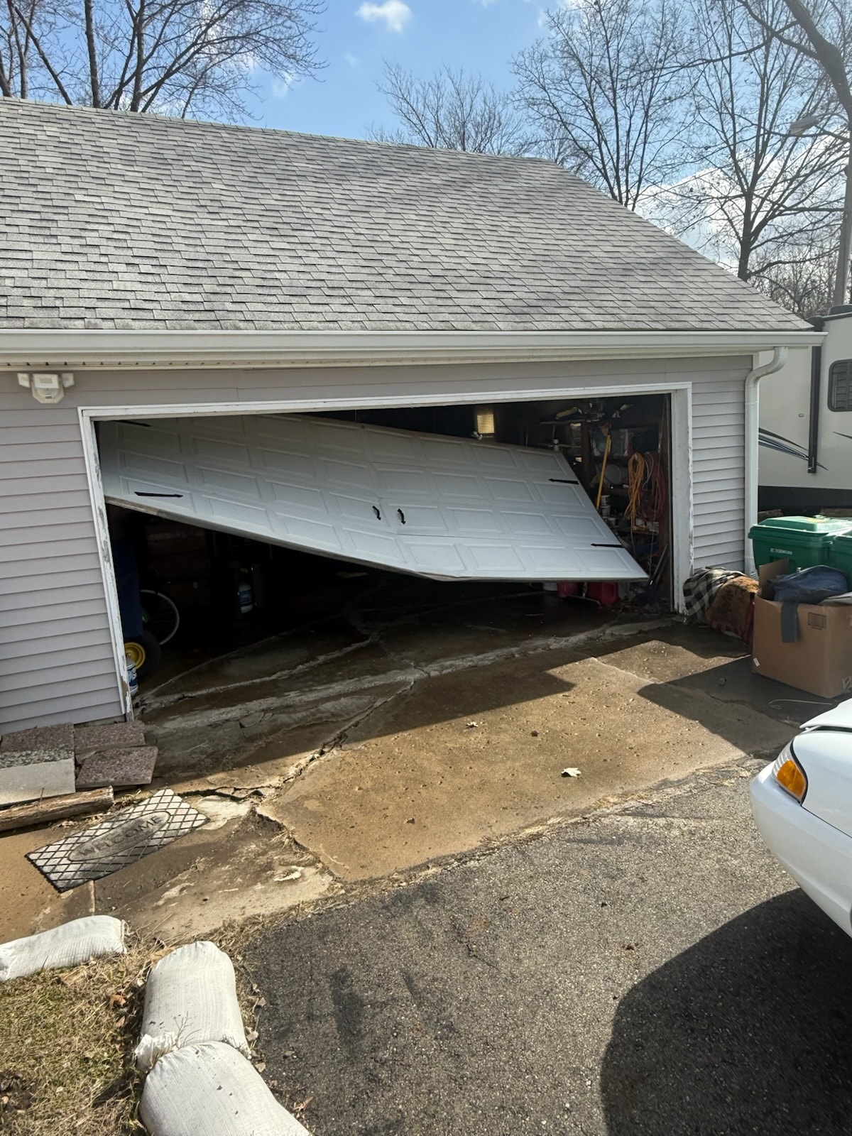 Collapsed garage door panel — damage requiring full replacement